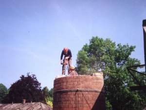 Praca na wysokości, wyburzanie komina ceglanego.